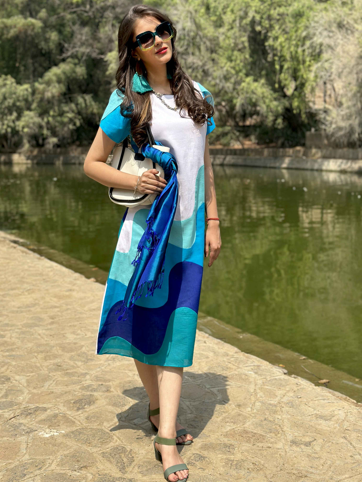 Frontal view of the dress with the model standing by a lake